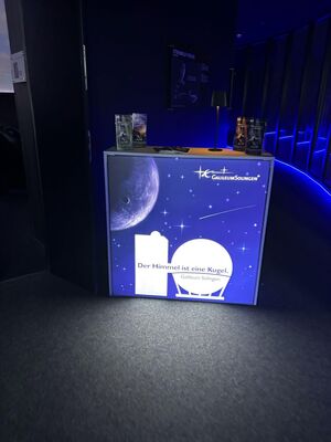 Im dunklen Eingangsbereich des Galileums ist eine erleuchtete Theke zu sehen.