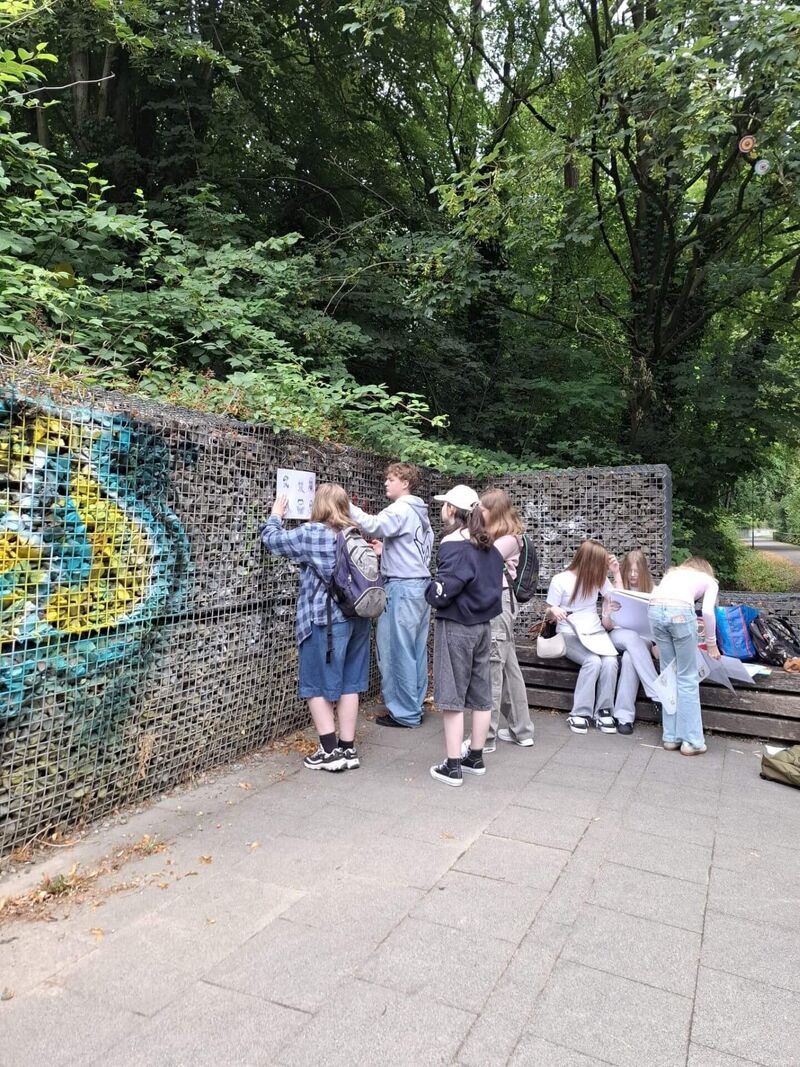 Eine Schülergruppe liest ein Informationsschild auf der Trasse.
