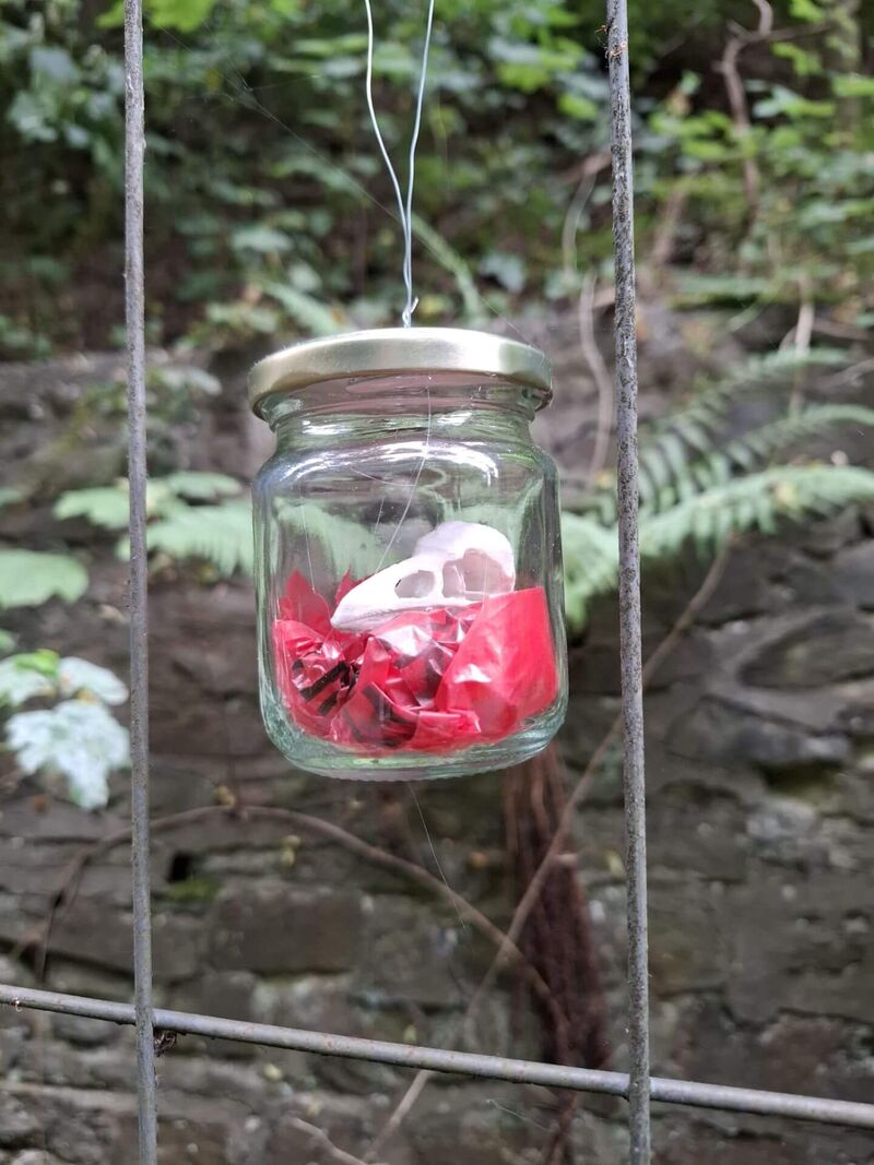 Ein Glas mit einem Vogelschädel wurde auf einem Geländer der Trasse drappiert.
