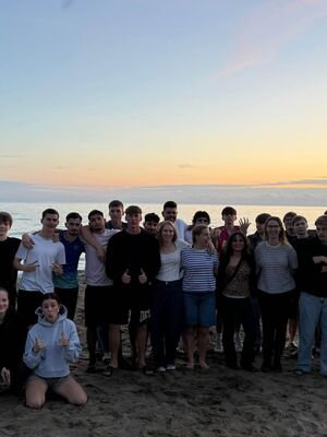 Der Jahrgang posiert vor einem Sonnenuntergang am Mittelmeer